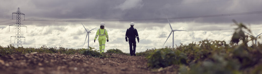 Two workers walking in a field.